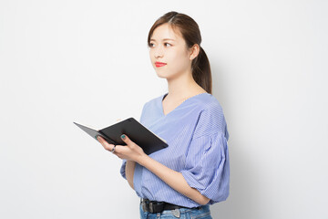 Fototapeta premium ノートにメモを書く若い女性