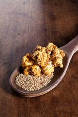 Top view of gourmet sesame seed popcorn over a wood cutting board background.