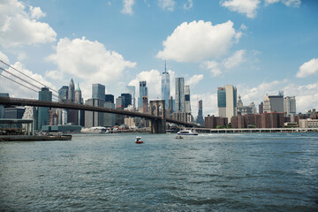 Fototapeta premium Hudson River and Brooklyn Bridge amid skyscrapers and large buildings of New York