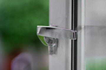 Metal handle of the vintage wooden window