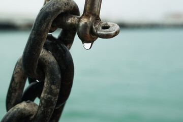 drop of rain hanging on a chain link
