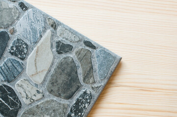 Sample of ceramic tiles. Gray marble. Stone surface. On wooden background