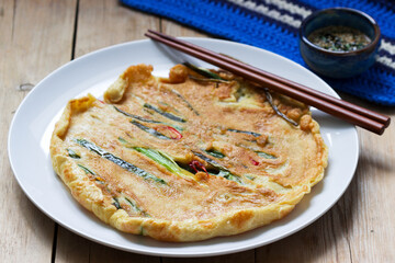 Traditional Korean fritters with green onions and chili, served with soy sauce.