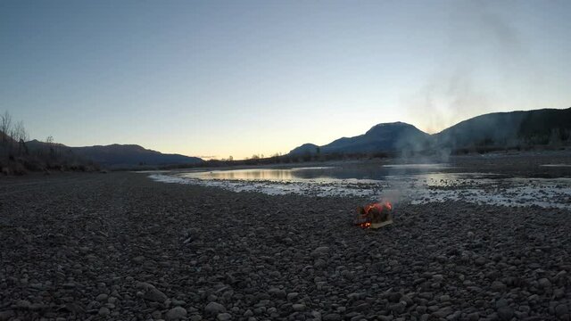 campfire on frozen river shore in norway