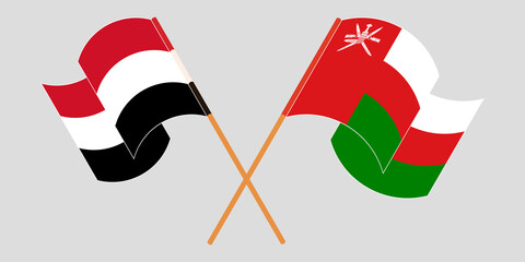 Crossed and waving flags of Oman and Yemen