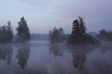 Early foggy morning on the lake in summer