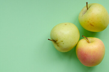 Fresh green apples on light green background with copy space.
