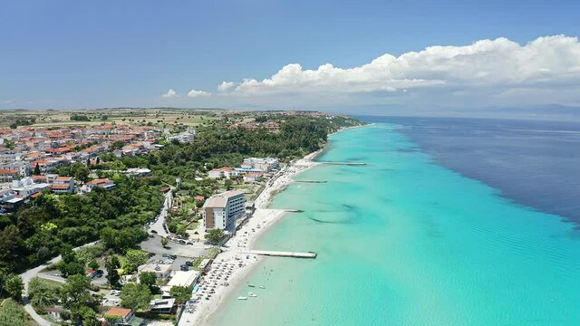 Aerial footage to coastline with turquoise sea and white sand. This beach located in the most popular village in Halkidiki- Kallithea. It is located in the first peninsula of Halkidiki, Kassandra.