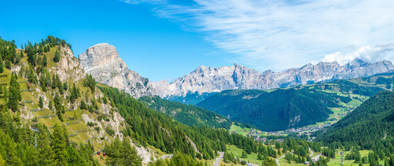 Naklejka na ściany i meble Panoramic view made from Passo Gardena of magical Dolomite peaks of Cima Cunturines in sunset colors at blue sky, South Tyrol, Italy, wide angle