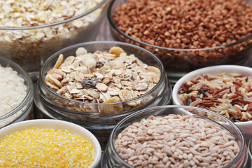 A set of bowls filled with different seeds: buckwheat, rise, corn and oatmeal	