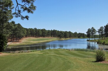 Lake on a golf course green surrounded by trees - 357061081