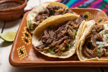 Mexican slow cooked lamb tacos also called barbacoa on white background