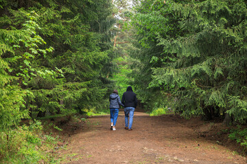 woman and man hand in hand in forest
