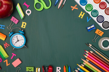 Back to school shopping concept. Top above overhead view photo of colorful stationery and an apple isolated on greenboard