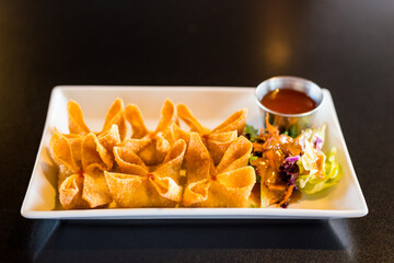 Crab Rangoon on a Tray with Side Salad.