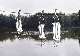 Masken hängen auf einer Wäscheleine am See