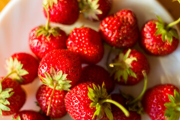 fresh ripe berries strawberries on ceramic plate, close up