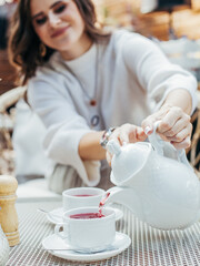 young woman pours herself tea