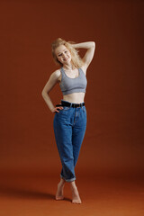 Model test with young beautiful blond woman on brown backdrop, isolated, natural