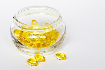 Glass jar of yellow medical pills on white background. Medical concept.