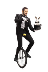 Magician riding a unicycle and performing a hat-trick with a rabbit © Ljupco Smokovski