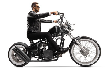Fototapeta na wymiar Profile shot of a biker on a custom chopper riding with sunglasses
