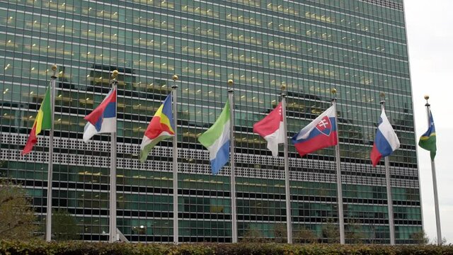 Multiple flags in front of the United Nations headquarters in New York City. Flags flying in the Wind in Slow Motion in Manhattan
