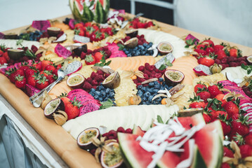 Colorful buffet table with various fresh fruits and vegetables. Celebration, party, birthday or wedding concept.
