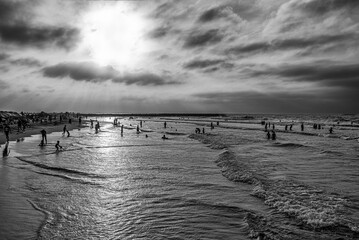 People taking a bath on the sea at sunset on B&W
