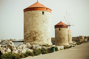 old fortress in the city of Rhodes Greece. The historic windmills at the Mandraki harbor in Rhodes town. Rhodes Island, Greece. Windmills with blue sky Mykonos Island Greece Cyclades. Windmills 
