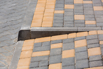Ramp for the descent of wheeled vehicles from the pedestrian sidewalk onto the road paved with...