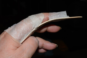 Homemade finger brace or splint for index finger injury made from slightly curved popsicle stick...