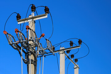 High voltage concrete and steel electrical power post top close up with transformers, ballast,...