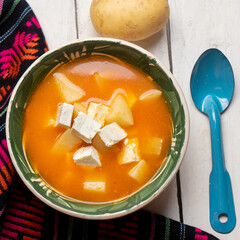 Mexican potato soup with panela cheese on white background