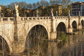 Fototapeta premium Arches and statues of Rome's Bridge of Angels spanning the Tiber River.