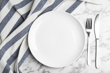 Empty plate with cutlery and fabric on white marble table, flat lay - Powered by Adobe