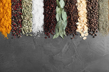 Different spices on grey background, top view. Space for text