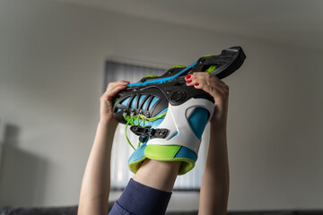 close up on foot of unknown caucasian woman in air taking off or putting on the rollerblade inline...