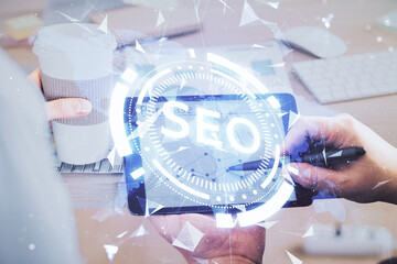 Multi exposure of man's hands holding and using a digital device and seo drawing. search...