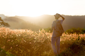 Fototapeta premium Backpacker. Young traveler with sunset in the background