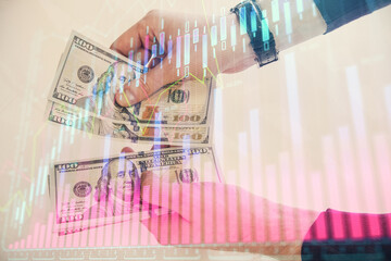 Multi exposure of financial graph drawing hologram and USA dollars bills and man hands. Analysis concept.