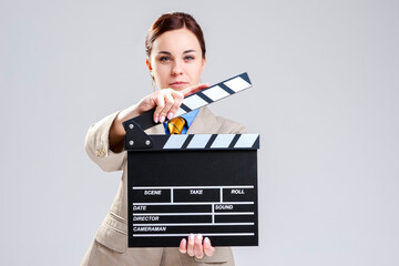 Cinema Concepts and Ideas. Portrait of Female Film Director Posing with Actioncut. Against Gray...