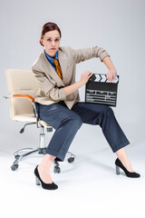 Full Length Portrait of Brunette Caucasian Woman in Shirt and Tie Posing in Chair with Actioncut.