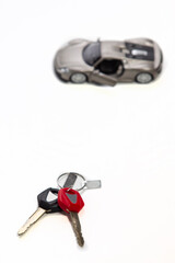 Car Loans and Credit Concepts. Blurred Car  Along With bunch of Keys Against White Background.