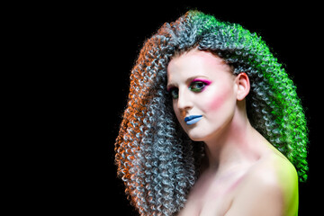 Creative Ideas. Portrait of Caucasian Girl With Frizzy Colorful Hair and Artistic Eyes Makeup. Posing Against Black.