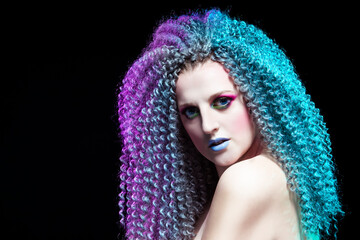 Creative Ideas. Portrait of Calm and Sensual Caucasian Girl With Frizzy Colorful Hair and Artistic Eyes Makeup. Against Black.