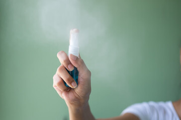 Asia woman hand using a spray bottle isolated on background ,Antibacterial hand sanitizer
