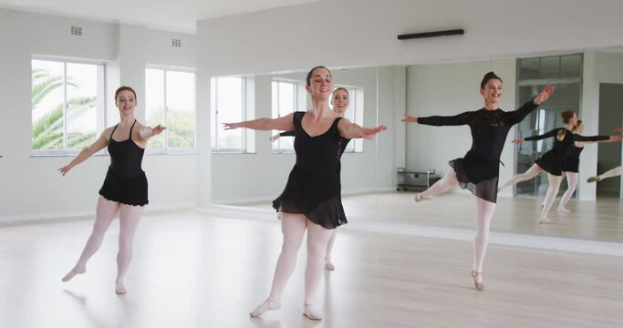 Caucasian female ballet dancers practicing a dance routine during a ballet class