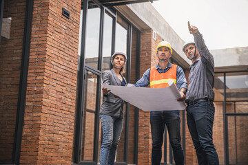 Obraz premium Engineer and business woman in hardhat posing on building site. civil engineer or architect with hardhat on construction site checking schedule on plan.