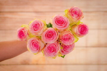 Women hand holding a bouquet of Esperance roses variety, studio shot.
